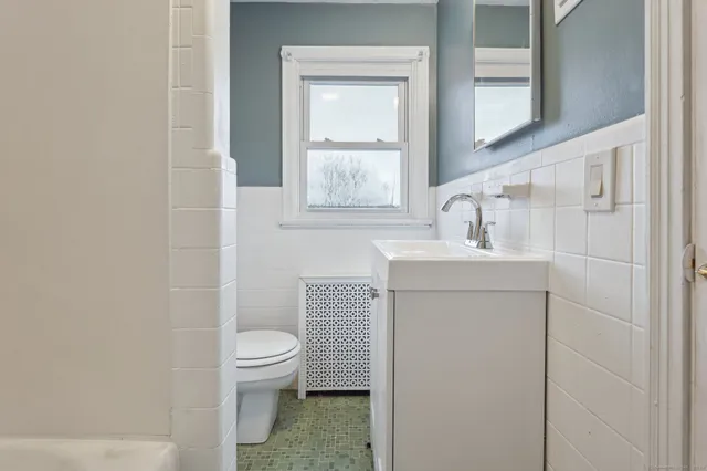 a bathroom with a sink toilet and window