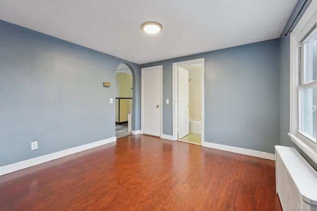 an empty room with window and wooden floor
