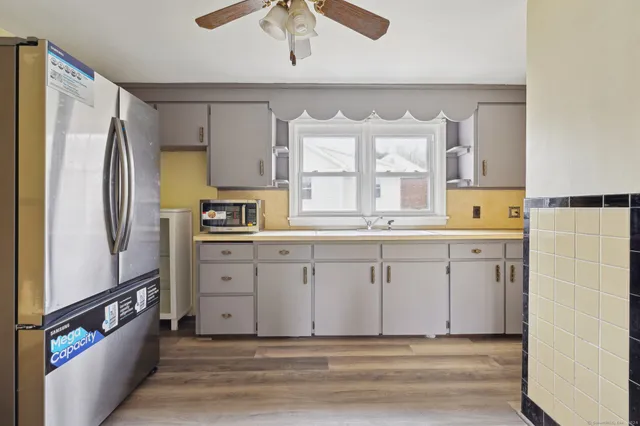 a kitchen with white cabinets and refrigerator