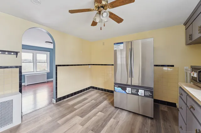 a view of a kitchen with wooden floor and electronic appliances
