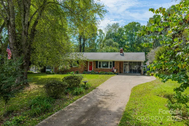 a front view of a house with yard and green space