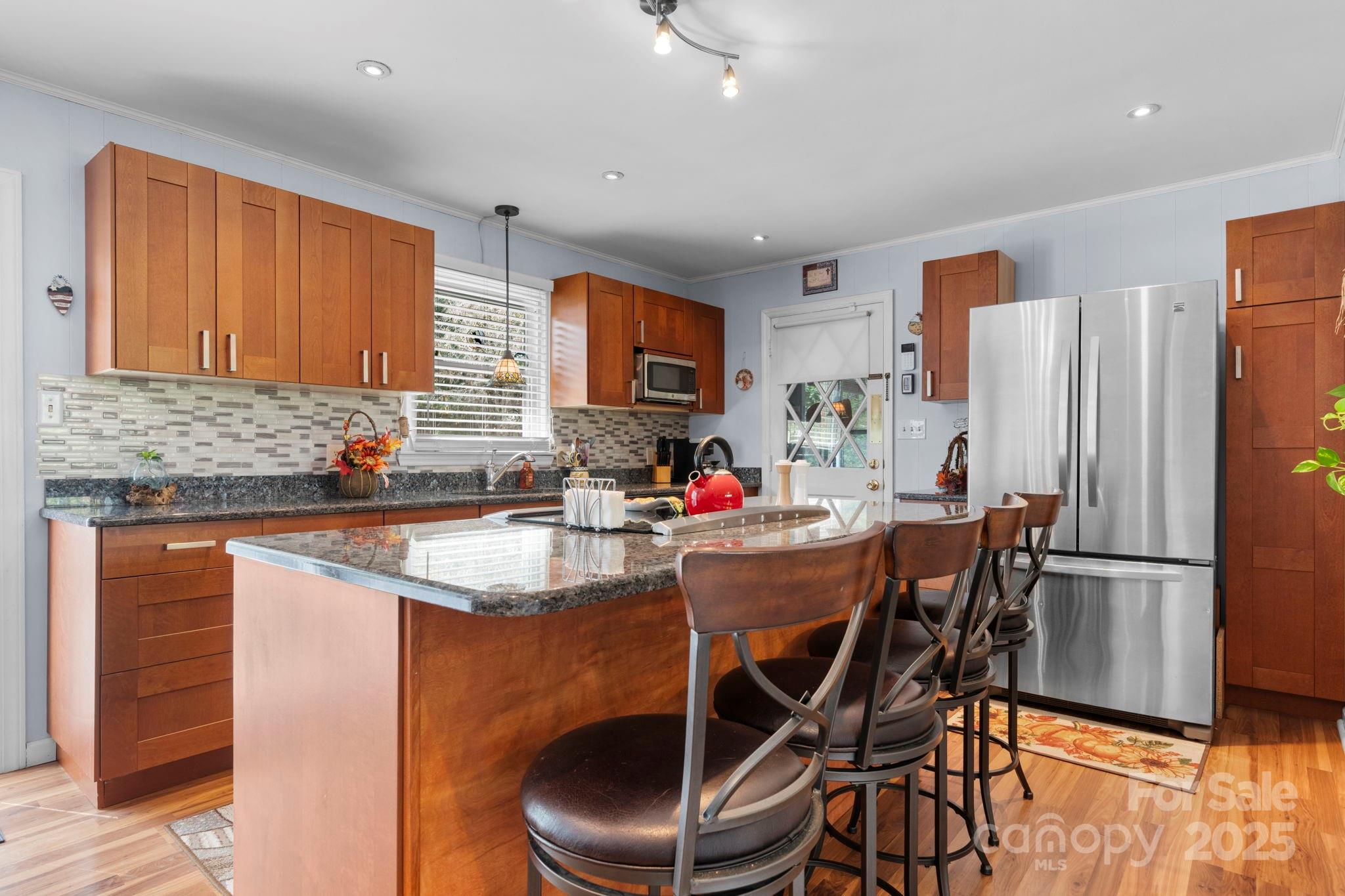 3651 Pea Ridge Road Morganton, NC 28655 - Photo 15 of 43 a kitchen with stainless steel appliances granite countertop a table chairs sink refrigerator and microwave