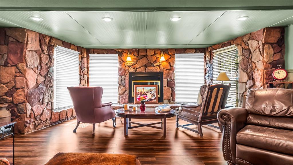 Living area with recessed lighting, wood finished floors, and a fireplace