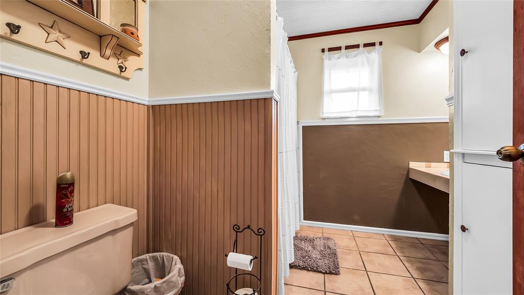 193 Eisenhower Road Denison, TX 75020 - Photo 14 of 30 Half bath featuring tile patterned floors and ornamental molding