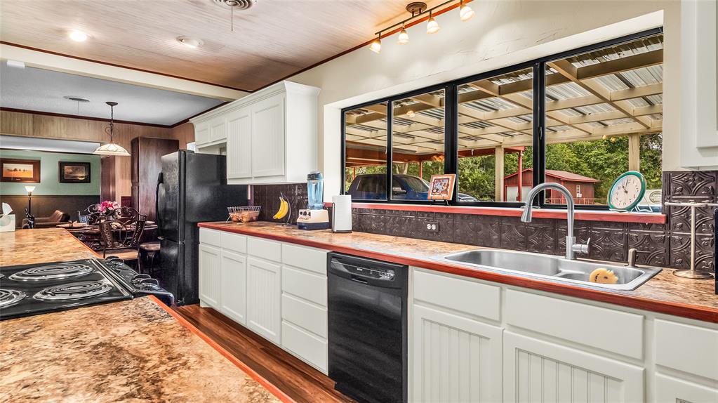 193 Eisenhower Road Denison, TX 75020 - Photo 6 of 30 Kitchen with white cabinets, black appliances, dark wood-style flooring, decorative light fixtures, and light countertops