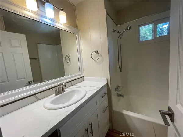 a bathroom with a sink shower and a mirror