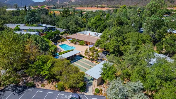 an aerial view of a house with backyard and outdoor seating