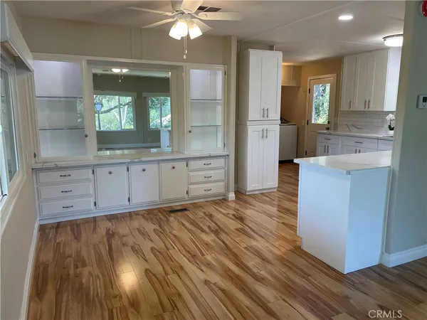 a large kitchen with kitchen island white cabinets and stainless steel appliances