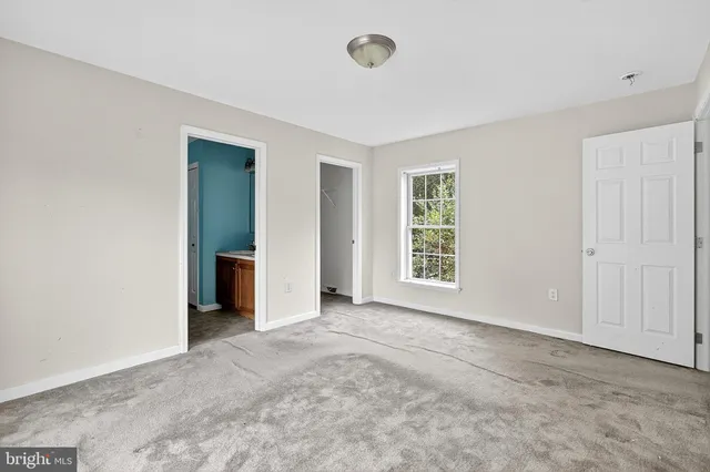 an empty room with windows and closet
