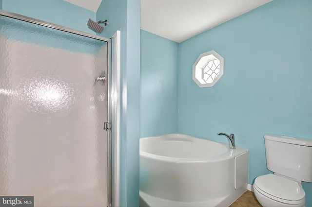 a white toilet sitting next to a bathroom sink and tub