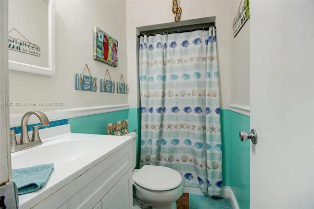 a bathroom with a sink a toilet and shower curtain