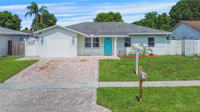 a front view of house with a garden and yard