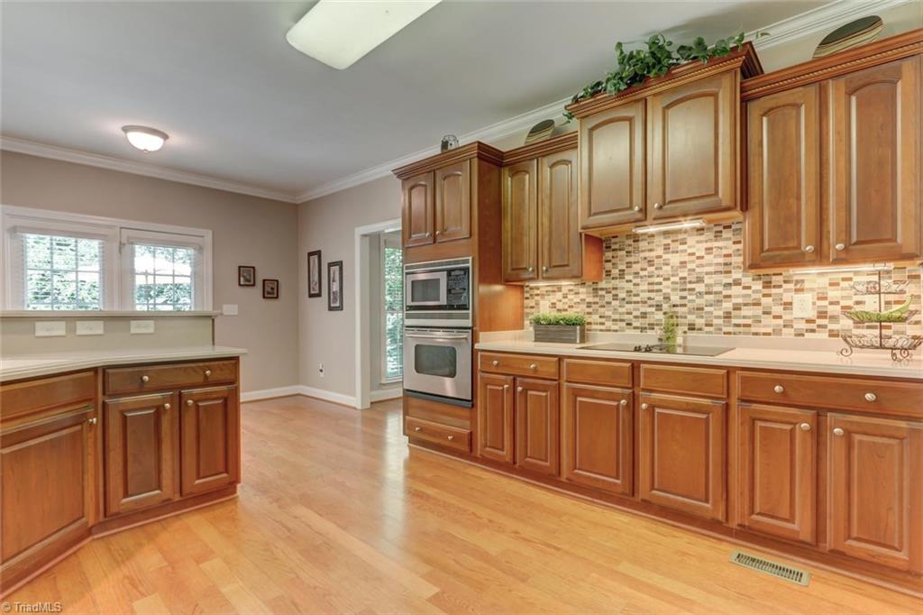 605 Stafford Pointe Court Oak Ridge, NC 27310 - Photo 12 of 30 The beautiful custom cabinetry, tile backsplash, and solid surface counter tops are evident that care was taken in designing this area