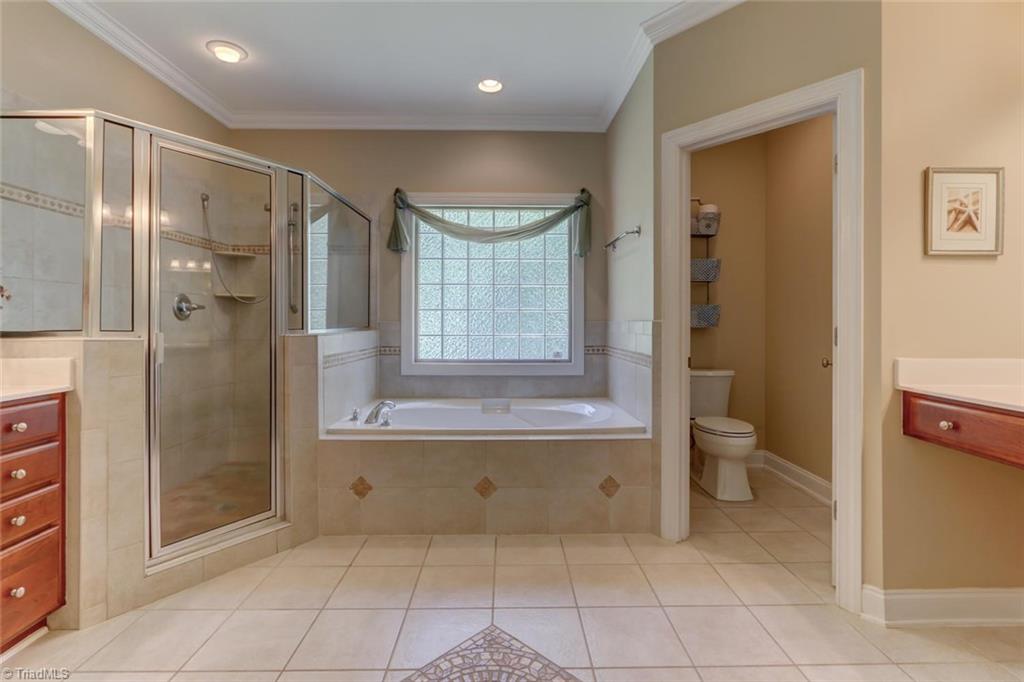 605 Stafford Pointe Court Oak Ridge, NC 27310 - Photo 18 of 30 The owner's bathroom has two separate vanities, a soaking tub, and a large tiled shower that will offer you a place to escape in the evening or to take a quick shower in the morning.