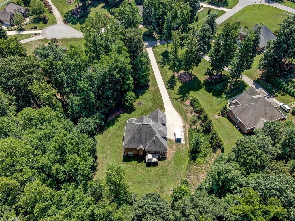 605 Stafford Pointe Court Oak Ridge, NC 27310 - Photo 29 of 30 This aerial view of the back of the home shows you the beautiful tree canopy that makes this home and neighborhood so peaceful