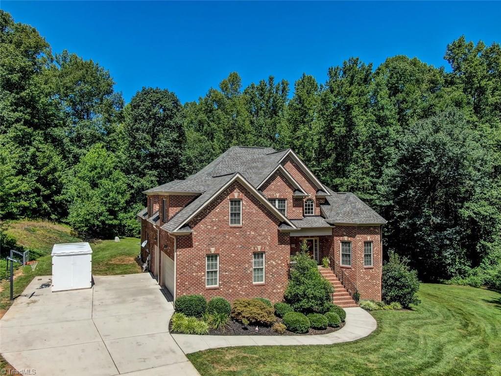 605 Stafford Pointe Court Oak Ridge, NC 27310 - Photo 4 of 30 The drive leads to the side entry 3 car garage and a concrete for a basketball court or additional parking if desired