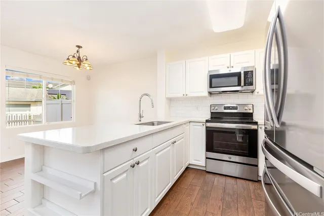 a kitchen with stainless steel appliances a stove microwave and sink