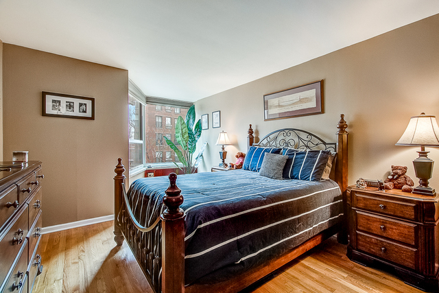 720 West Gordon Terrace, Unit 5B Chicago, IL 60613 - Photo 10 of 20 a bed sitting in a bedroom next to a lamp with window