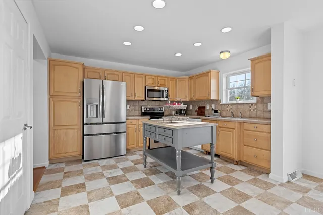 a kitchen with a refrigerator a sink dishwasher and a stove with wooden floor