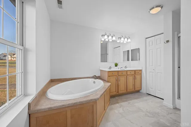 a bathroom with a tub sink and mirror