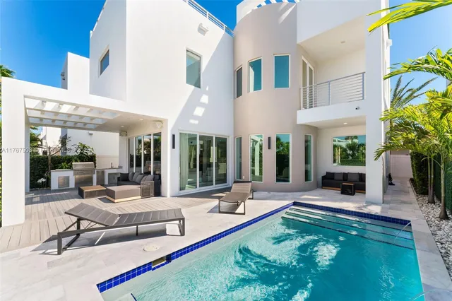 a view of a patio with couches table and chairs under an umbrella