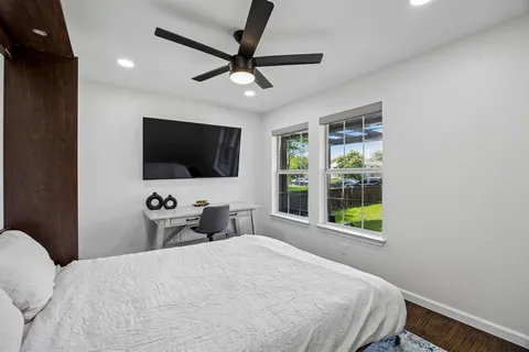 a bedroom with a bed tv and a window