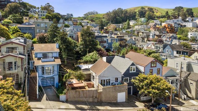 an aerial view of a city with lots of residential buildings and mountain view in back