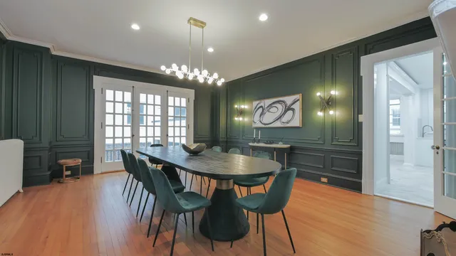 a view of a dining room with furniture a chandelier and wooden floor