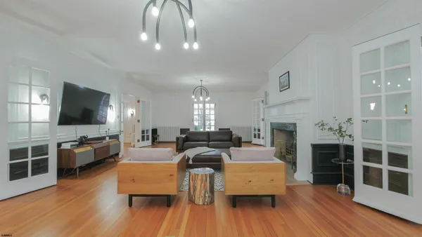 a living room with furniture a flat screen tv and kitchen view