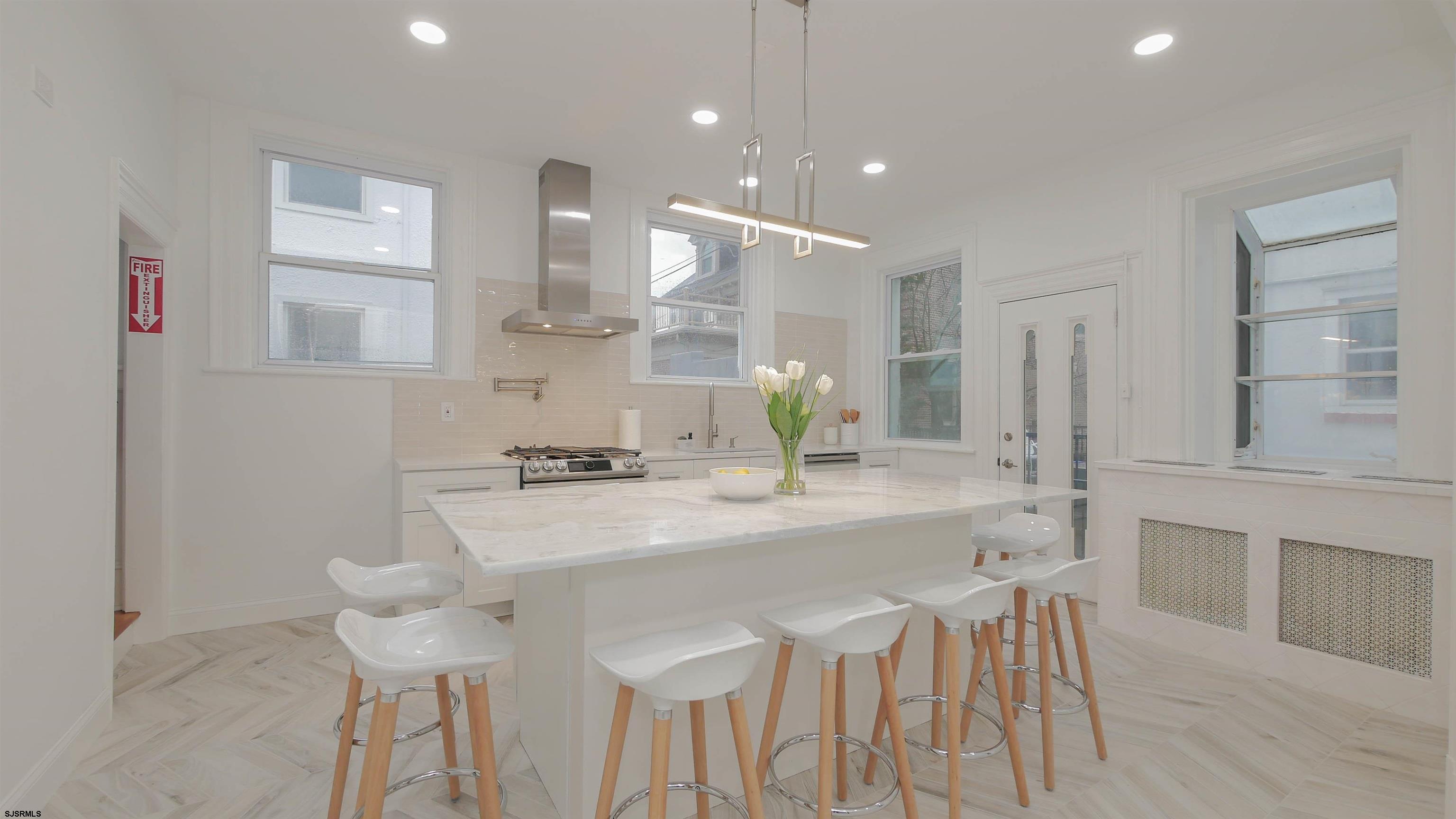 4700 Atlantic Avenue Atlantic City, NJ 08401 - Photo 17 of 74 a kitchen with stainless steel appliances kitchen island granite countertop a kitchen island and chairs in it