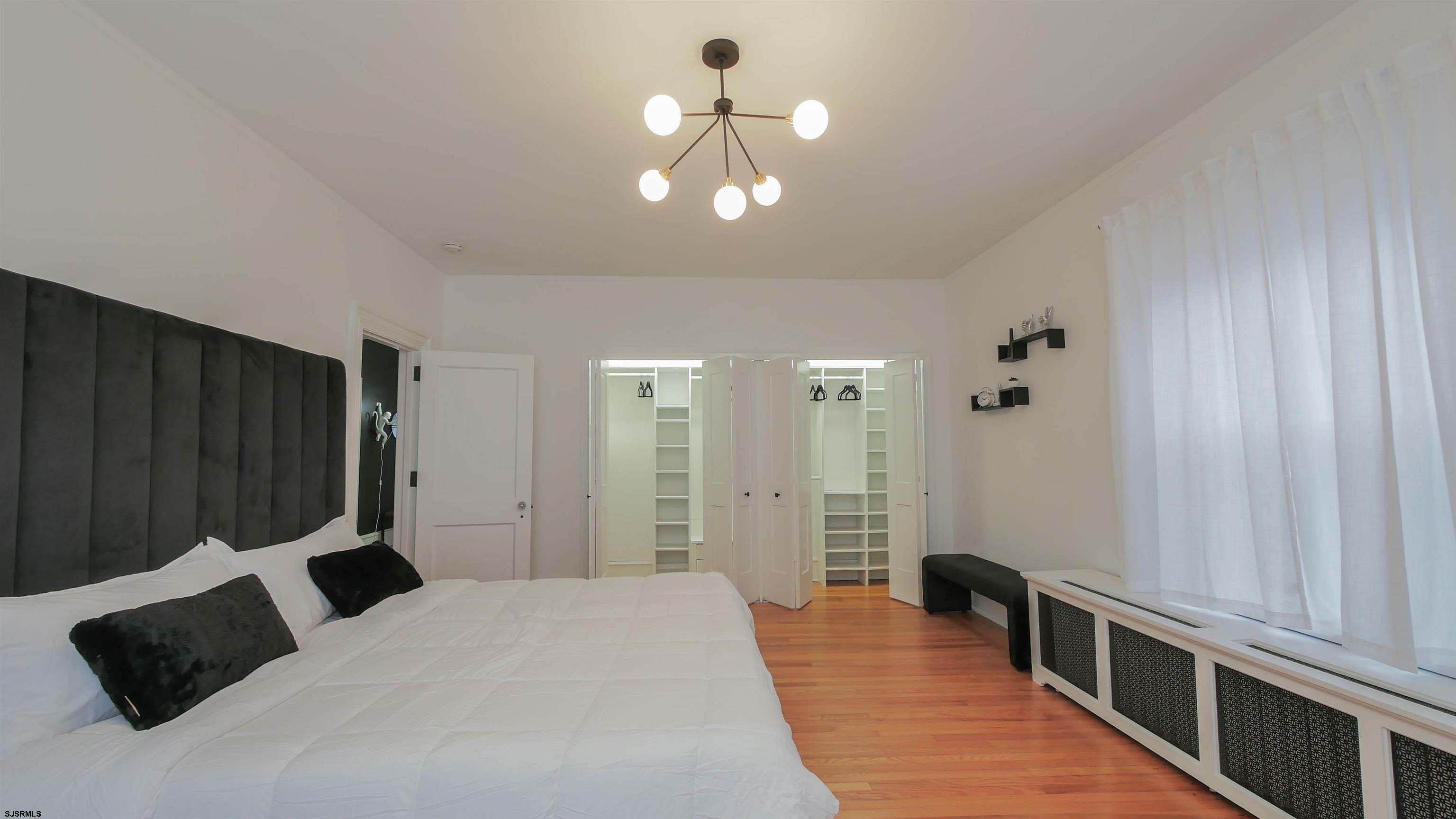 4700 Atlantic Avenue Atlantic City, NJ 08401 - Photo 36 of 74 a bedroom with a bed window and a chandelier