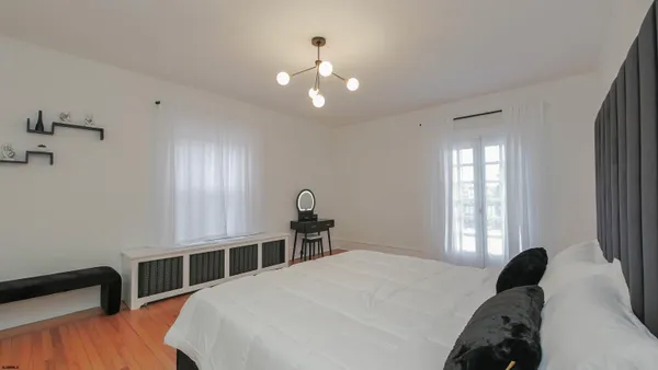 a bedroom with a bed and a chandelier