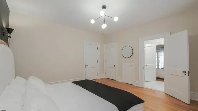 a spacious bedroom with two beds and wooden floor