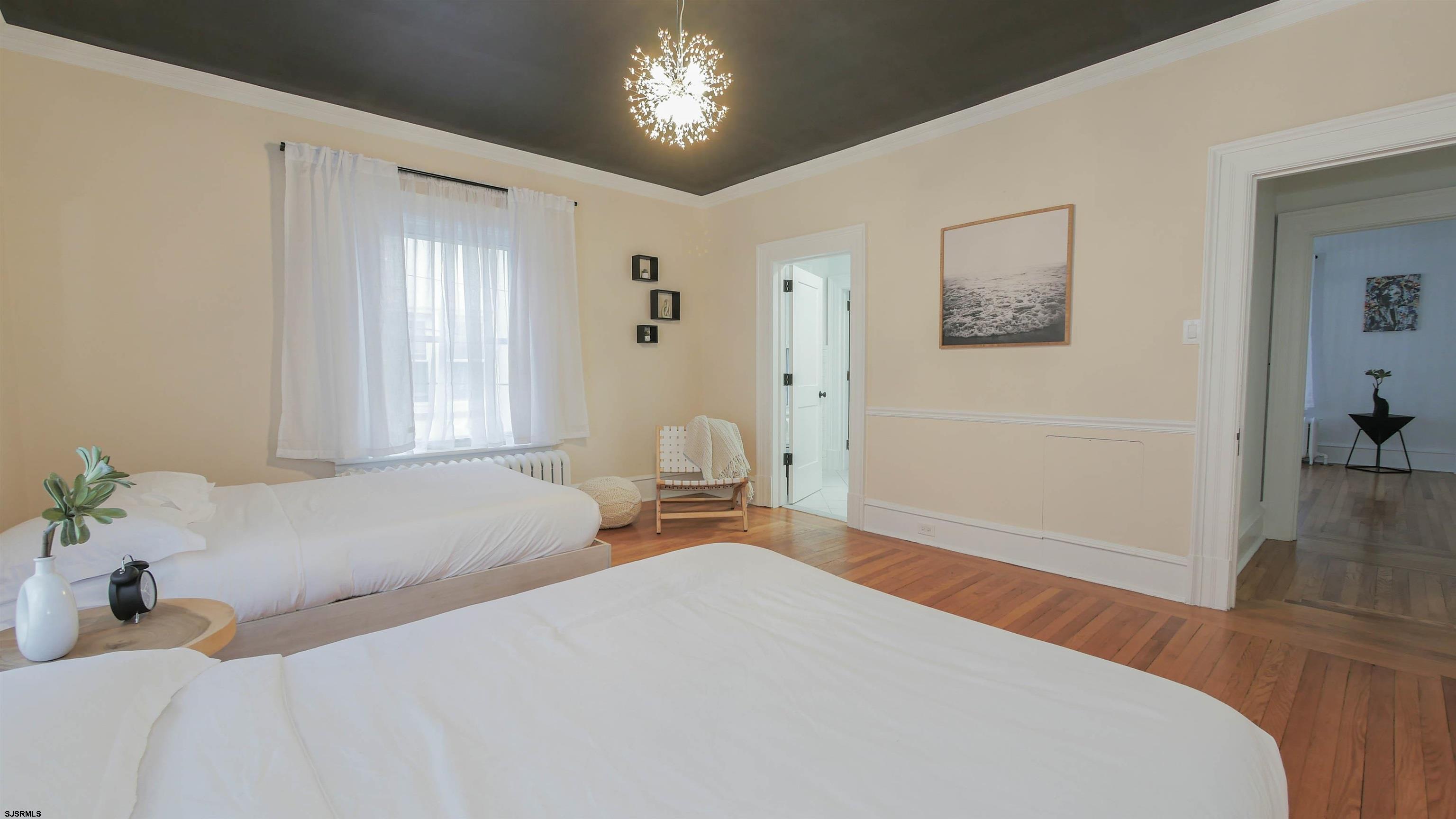 4700 Atlantic Avenue Atlantic City, NJ 08401 - Photo 50 of 74 a bedroom with a bed and a chandelier