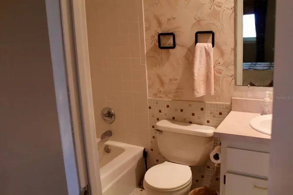 a white toilet sitting next to a bathroom sink