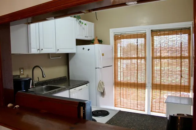 a kitchen with a sink a window and cabinets