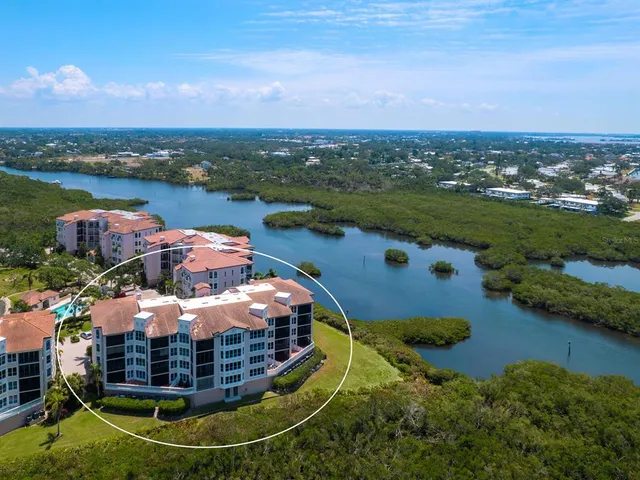 an aerial view of a house with outdoor space and lake view in back