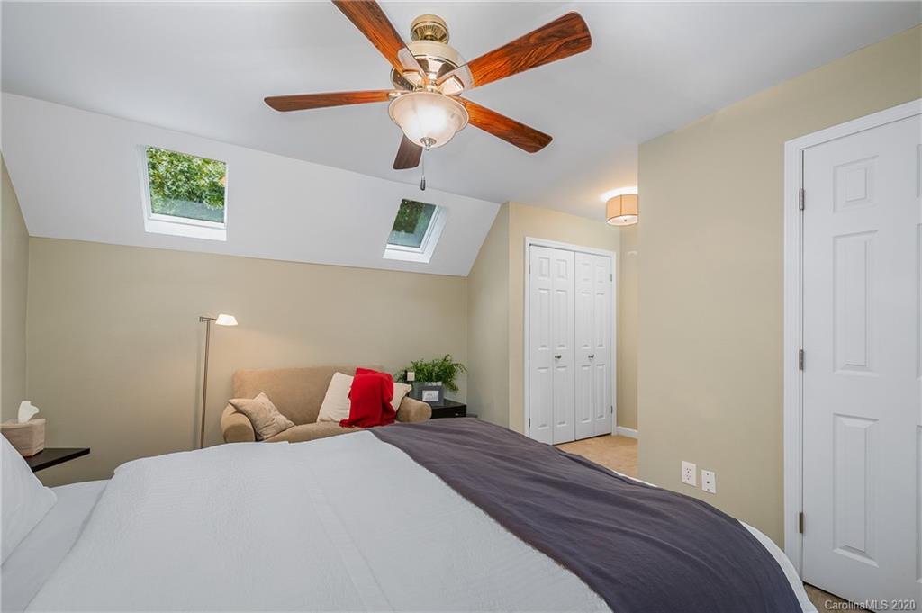 199 Chestnut Street Tryon, NC 28782 - Photo 24 of 29 a bedroom with a bed and a chandelier
