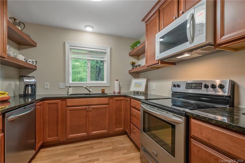 199 Chestnut Street Tryon, NC 28782 - Photo 9 of 29 a kitchen with stainless steel appliances granite countertop a sink and stove top oven