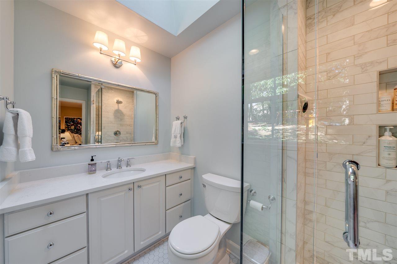 808 Davidson Street Raleigh, NC 27609 - Photo 15 of 30 a bathroom with a toilet a sink a mirror and shower