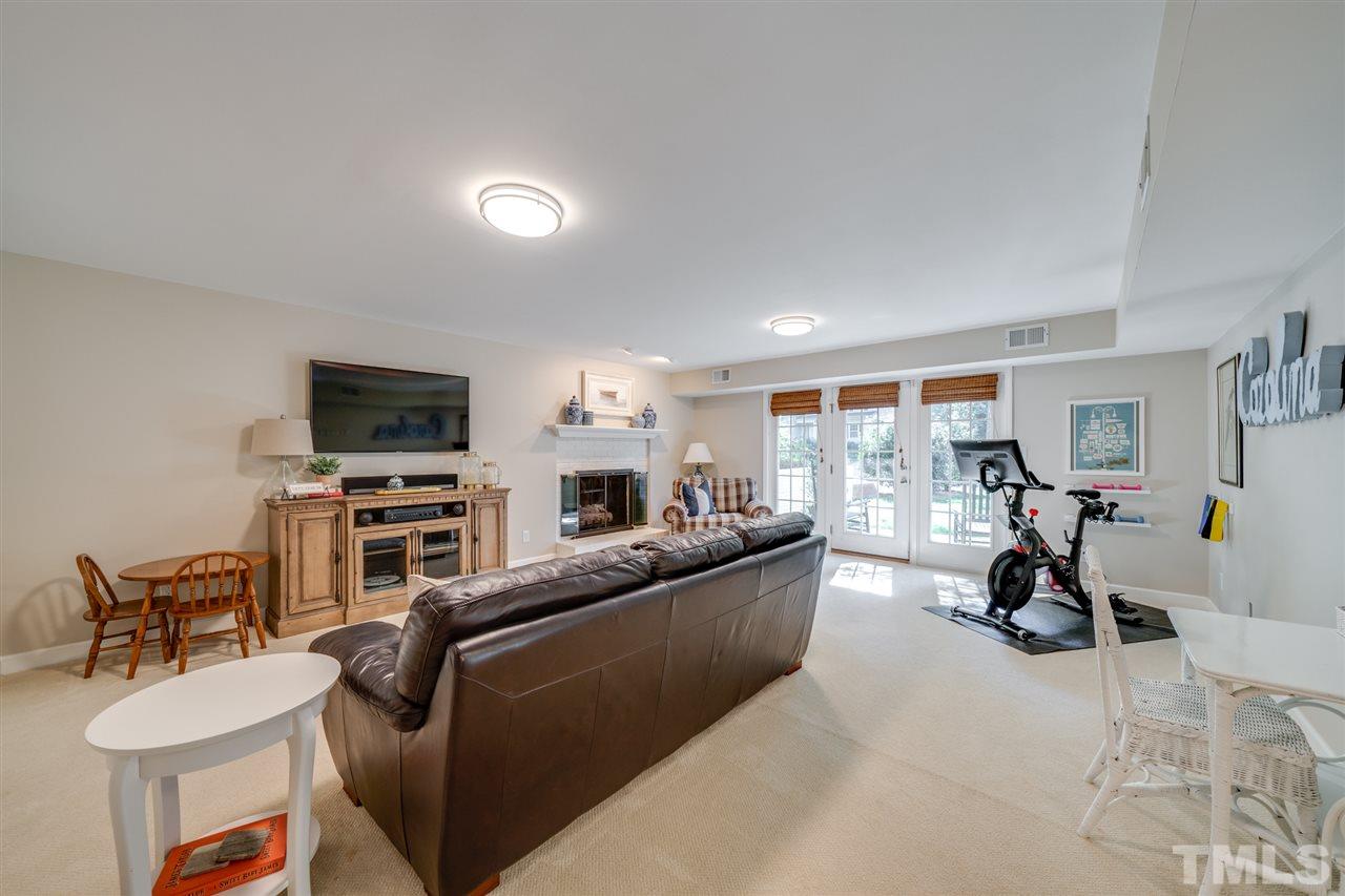 808 Davidson Street Raleigh, NC 27609 - Photo 22 of 30 a living room with furniture a flat screen tv and gym equipment