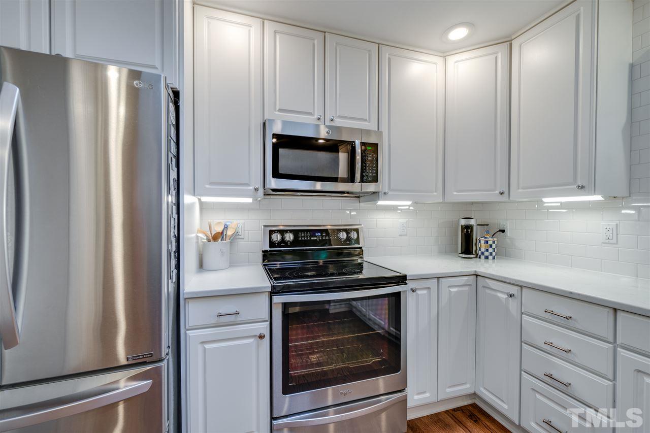 808 Davidson Street Raleigh, NC 27609 - Photo 8 of 30 a kitchen with white cabinets and stainless steel appliances