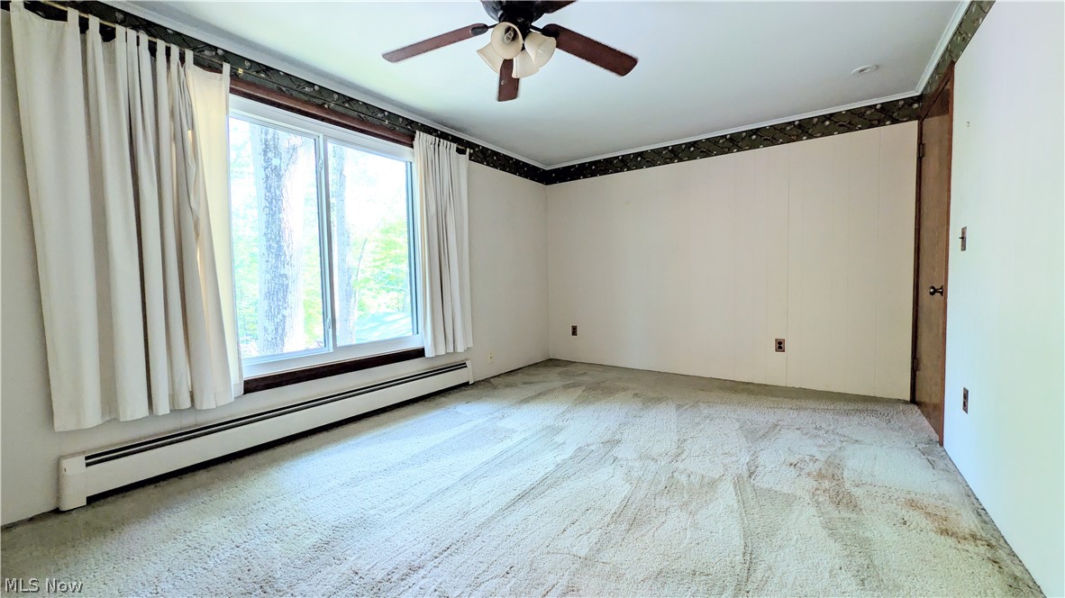 6409 Old Woods Road Ashtabula, OH 44004 - Photo 6 of 43 Spacious sunken living room featuring a large window, wall-to-wall carpeting, and a ceiling fan