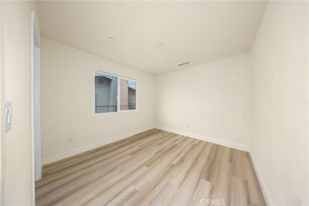 16241 Chestnut Street Hesperia, CA 92345 - Photo 34 of 60 an empty room with wooden floor and windows