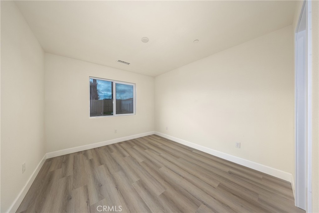 16241 Chestnut Street Hesperia, CA 92345 - Photo 37 of 60 an empty room with wooden floor and windows
