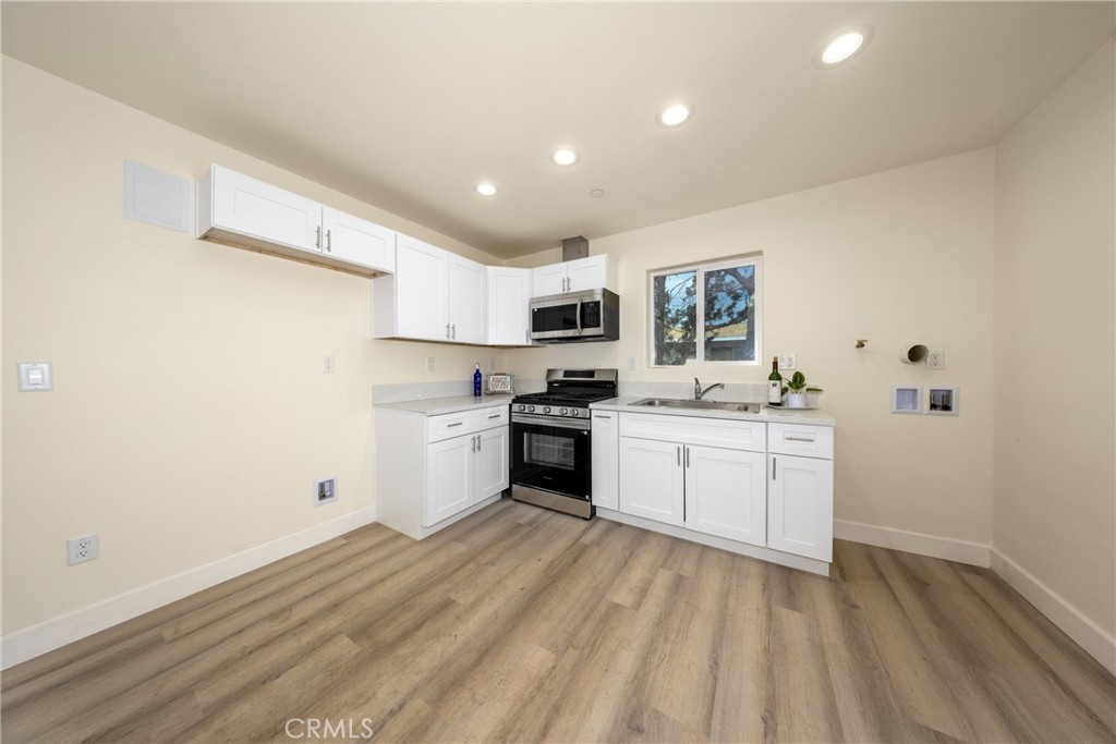 16241 Chestnut Street Hesperia, CA 92345 - Photo 45 of 60 a kitchen with granite countertop white cabinets and white appliances