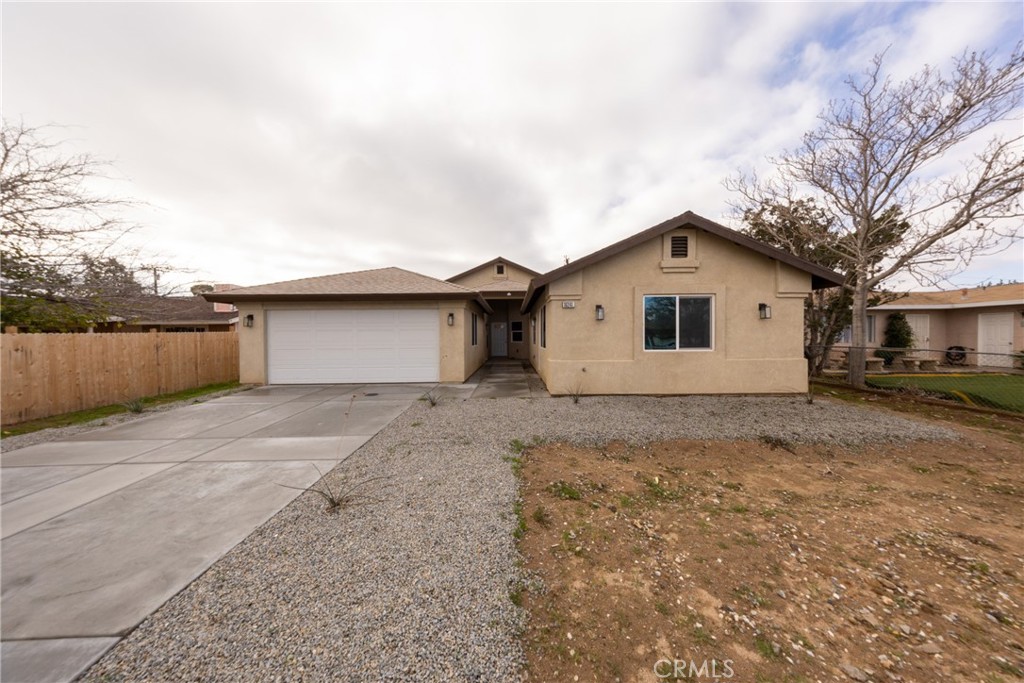 16241 Chestnut Street Hesperia, CA 92345 - Photo 6 of 60 a front view of a house with a yard and garage