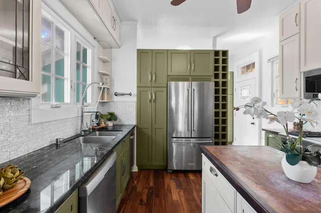 a kitchen with kitchen island a counter appliances a sink and cabinets