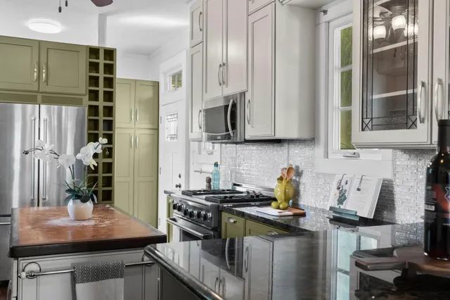 a kitchen with stainless steel appliances granite countertop a sink a stove and a wooden cabinets