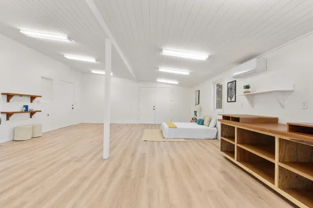 a bed room with a bed and a view of kitchen